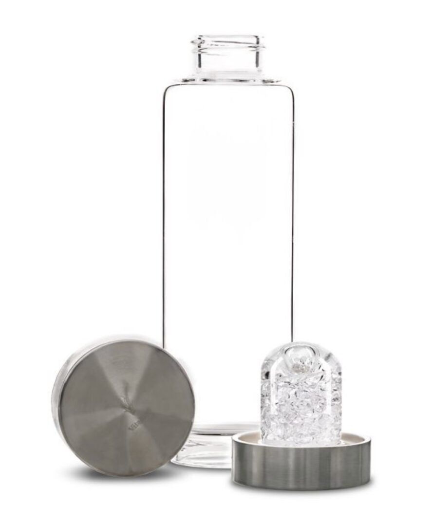Transparent glass water bottle with metal lid and ice cube inside.