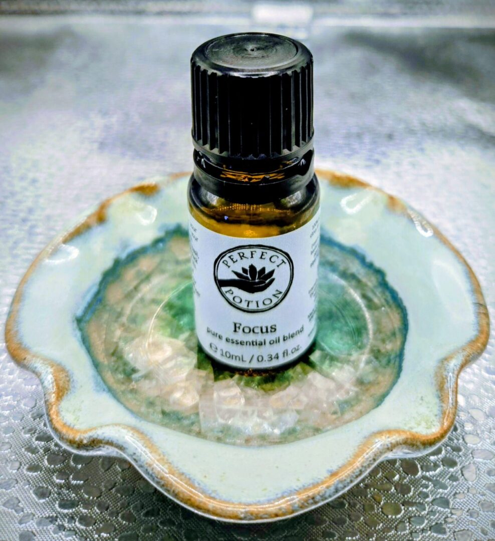 A bottle of Focus essential oil blend on a decorative ceramic dish.