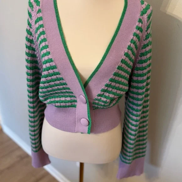 Purple and green striped cardigan with buttons on a mannequin.