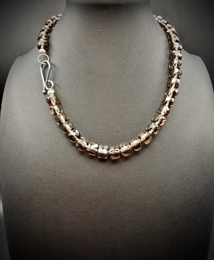 Elegant faceted brown bead necklace with silver clasp on display.