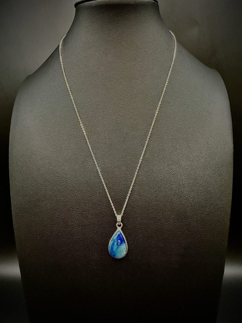 Elegant silver necklace with a teardrop-shaped blue gemstone pendant.
