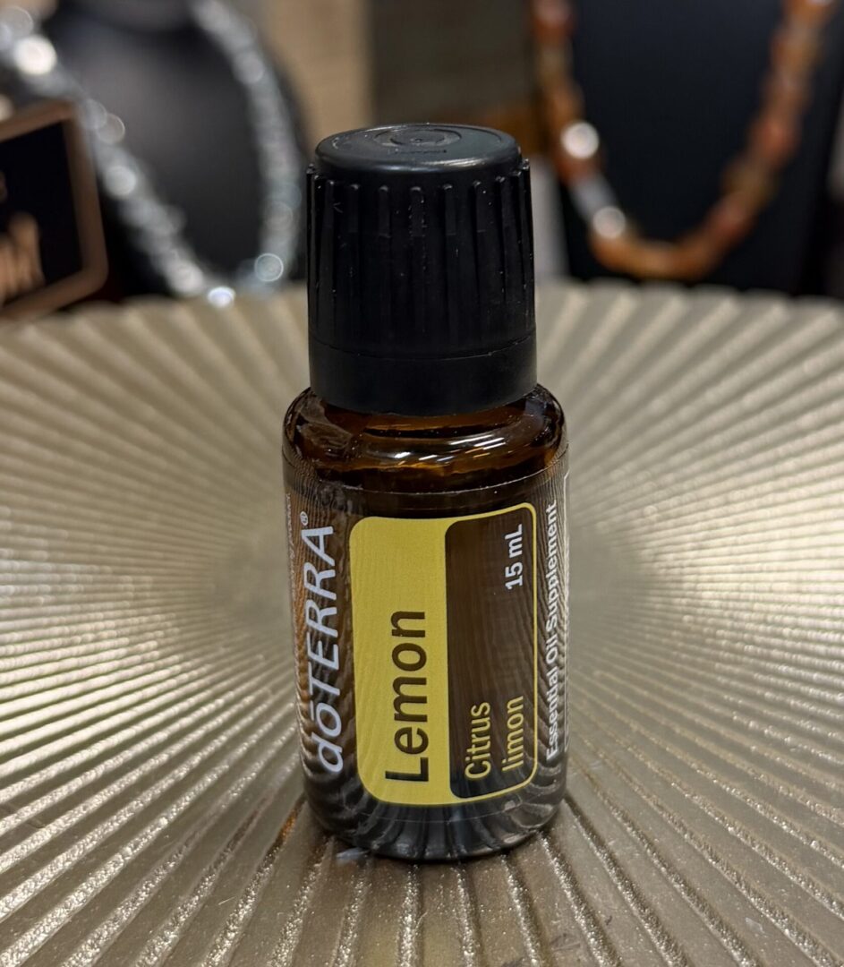 A small bottle of doTERRA Lemon essential oil on a textured surface.