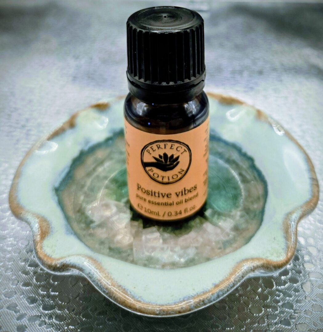 Small bottle of Positive Vibes essential oil on a decorative dish.